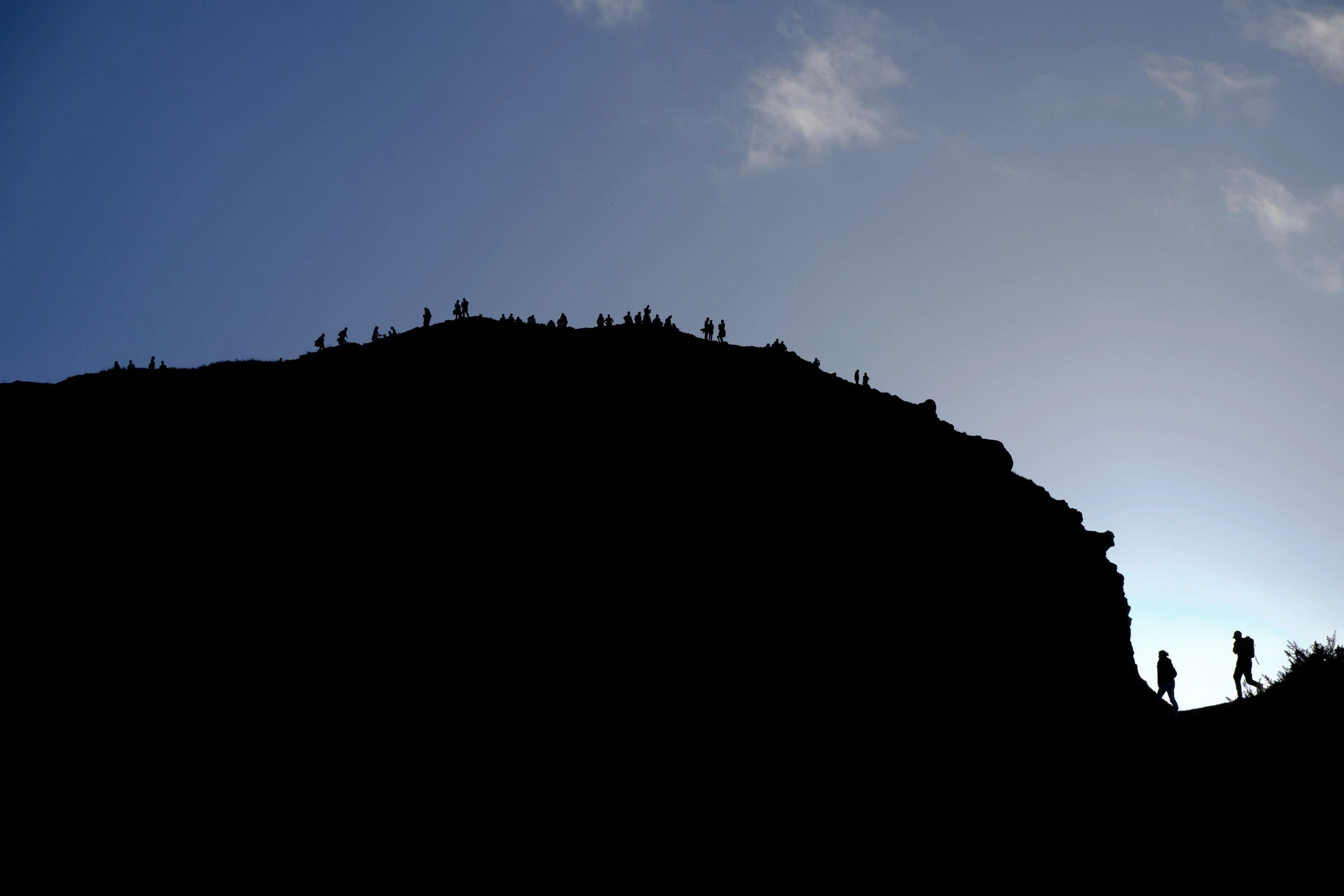 Rocky hiking trail silhouetted against a bright sky