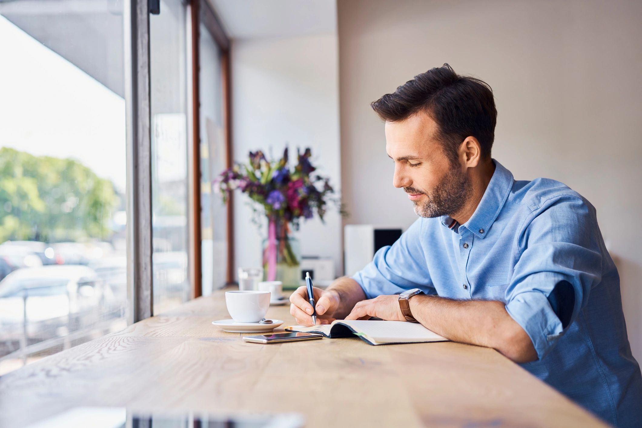 Person writing notes during a coffee break