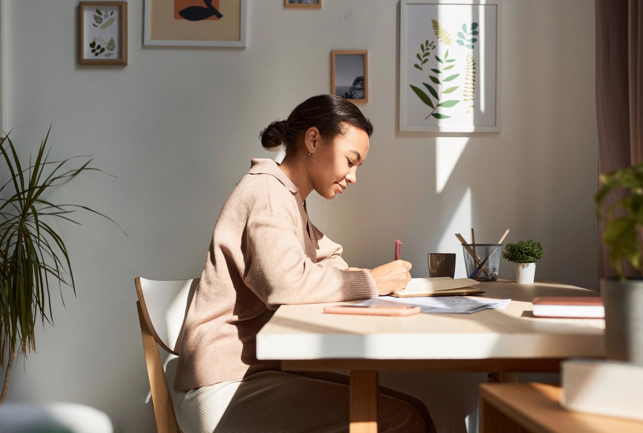 Person journaling in warm morning light, reflecting on next steps