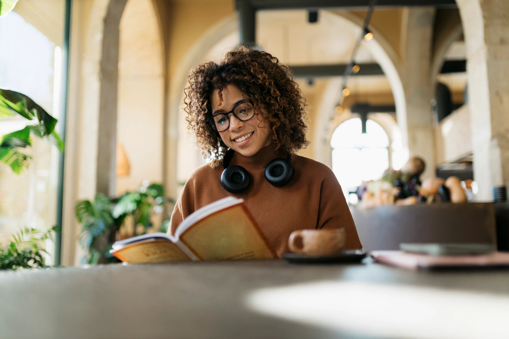 Smiling woman reading in a coffee shop