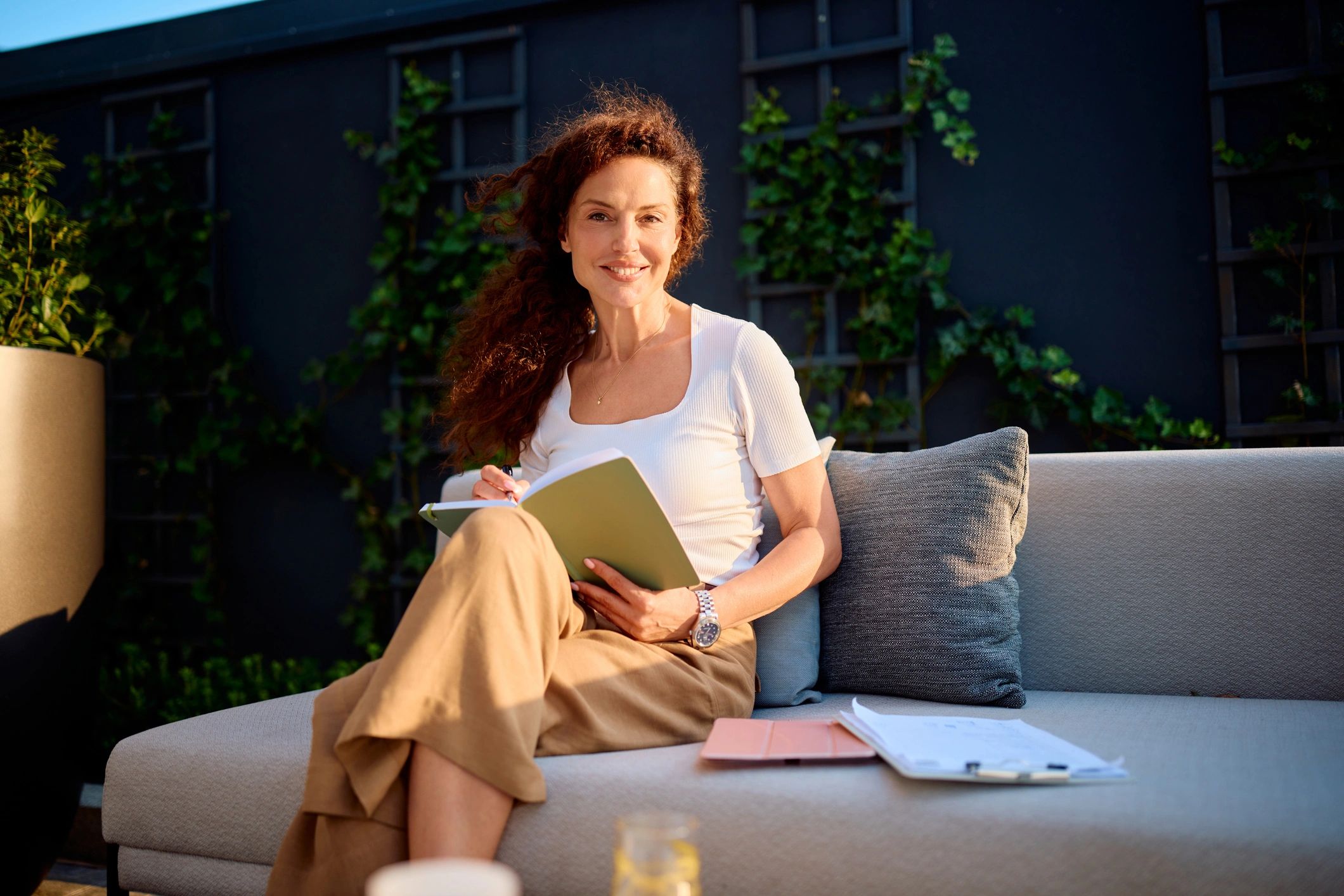 Businesswoman relaxing outdoors with a notebook