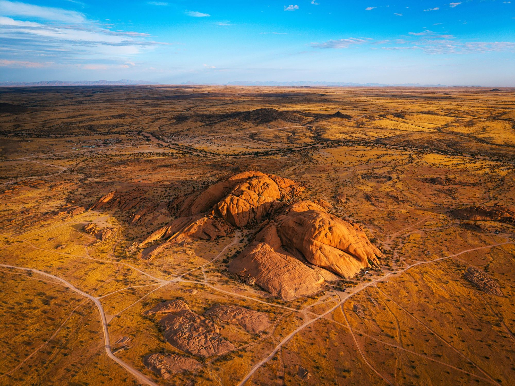 Wide desert landscape with winding road at sunset, evoking a fresh start and adventure