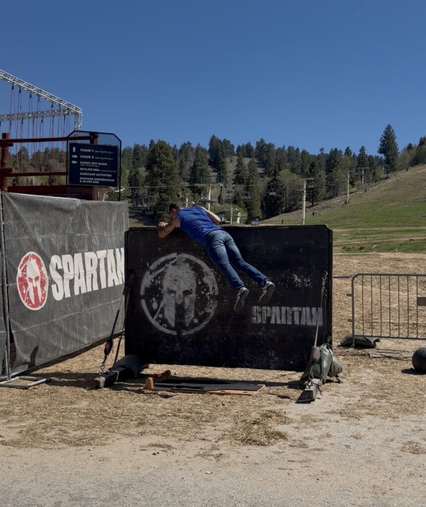 Spartan racer jumping down from the 8' wall climb onto a KORBOARD