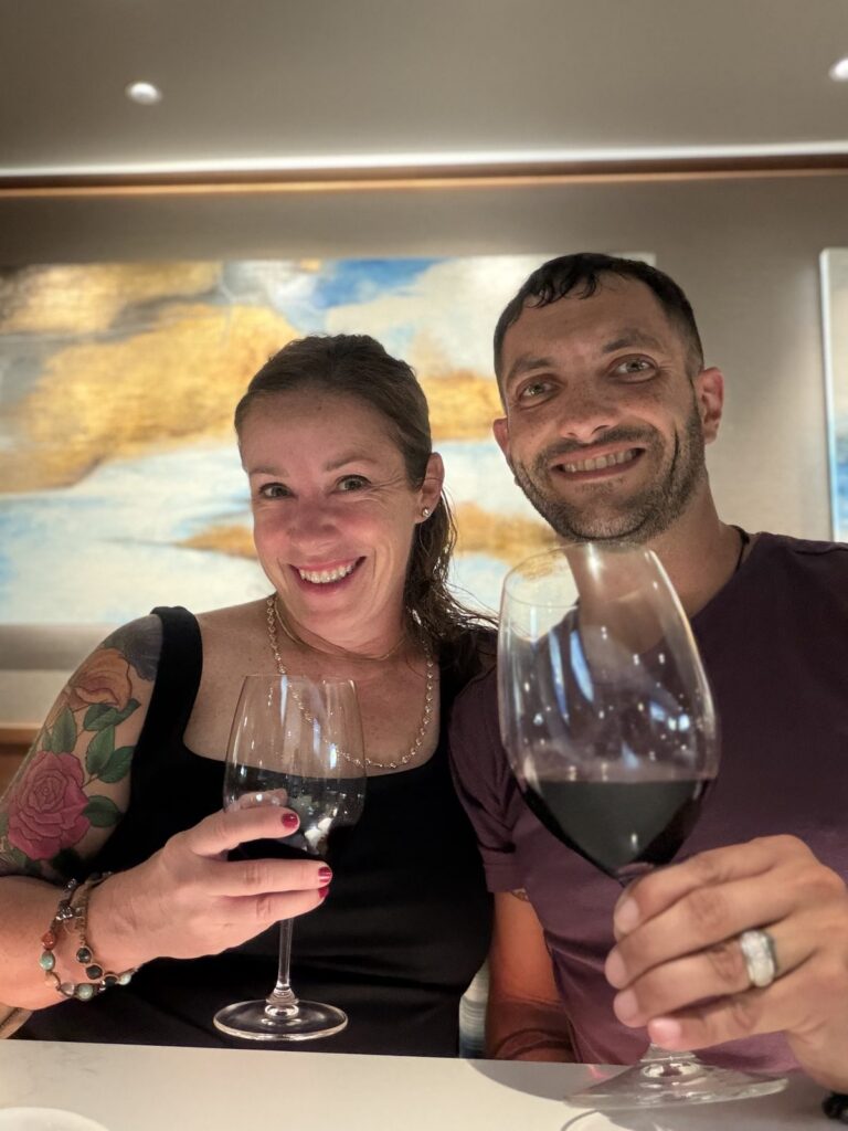 Amy and Mason toasting with red wine at her celebration dinner